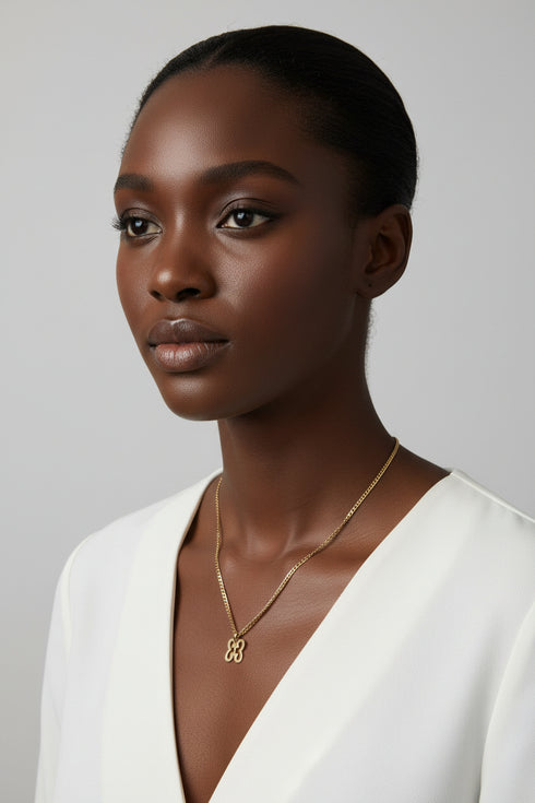 Gold chain with a floral clasp on a marble surface