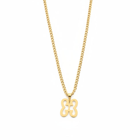 Gold necklace with a clover-shaped pendant on a marble surface