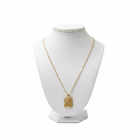 Gold necklace with a pendant on a white mannequin bust against a white background
