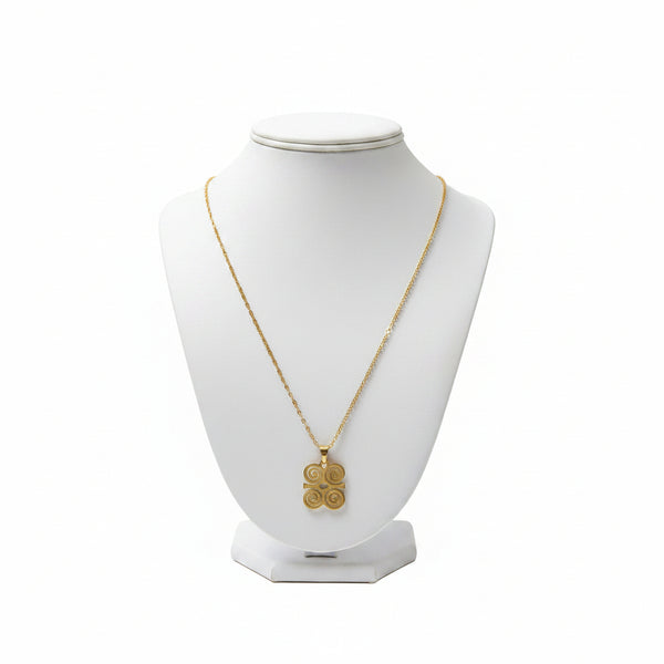 Gold necklace with a pendant on a white mannequin bust against a white background