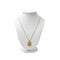 Gold necklace with a pendant on a white mannequin bust against a white background