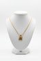 Gold necklace with a floral pendant on a marble surface