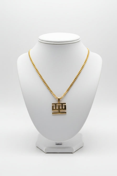 Gold chain necklace with a square pendant on a marble surface