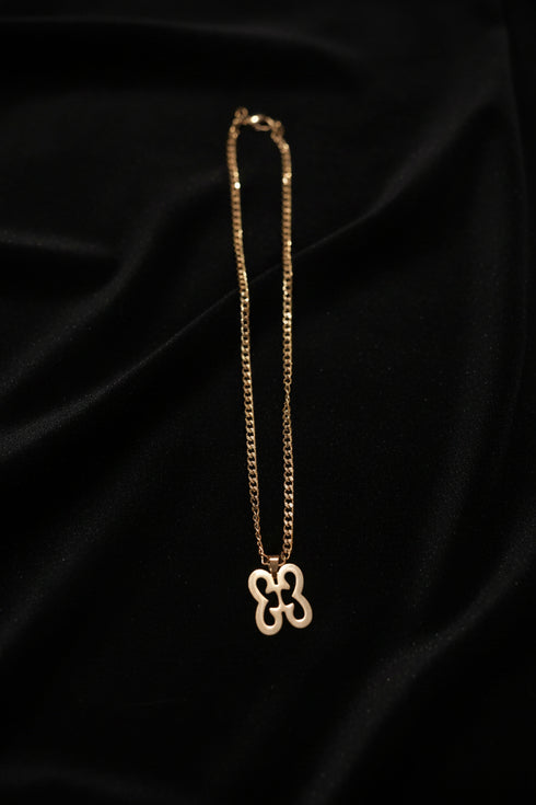 Gold chain with a decorative clasp on a marble surface