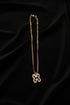 Gold chain with a decorative clasp on a marble surface