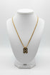 Gold chain with a decorative clasp on a marble surface