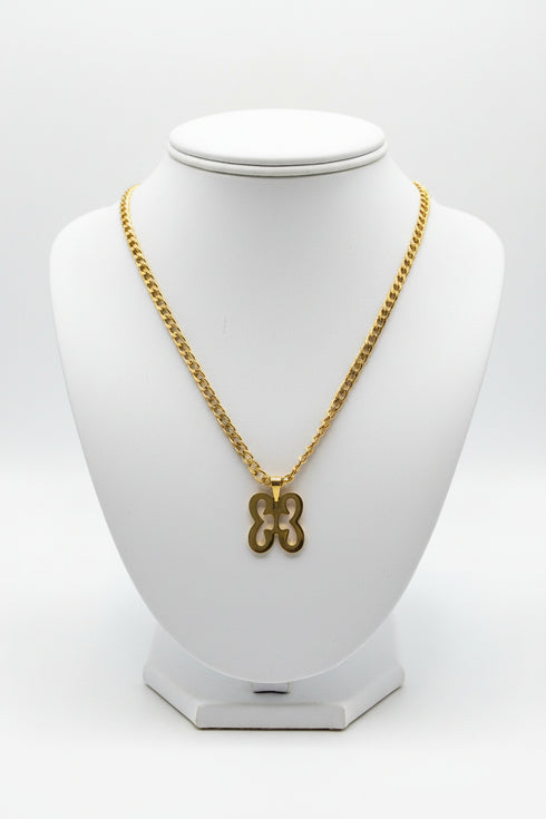 Gold chain necklace with a butterfly pendant on a marble surface