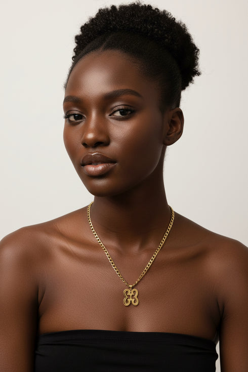 Gold chain with a decorative clasp on a marble surface