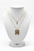 Gold necklace with a gold pendant on a marble surface