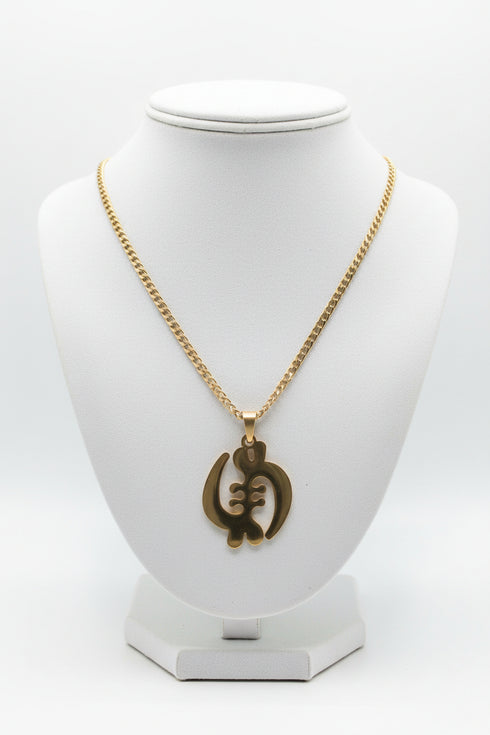 Gold necklace with a heart-shaped pendant on a marble surface