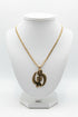 Gold necklace with a heart-shaped pendant on a marble surface