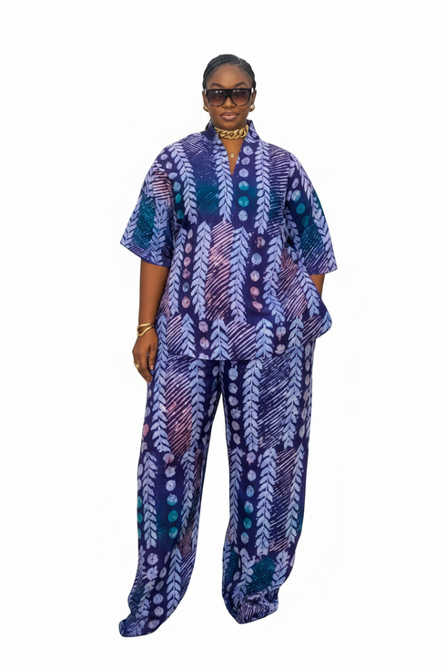 A woman modeling a matching two-piece outfit with a vibrant blue, purple, and white patterned kaftan top and wide-leg trousers, set against a plain white background.