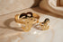 Gold guitar-shaped bracelet on a marble background