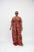 A woman modeling a red and orange patterned short-sleeve jumpsuit in an indoor setting with a striped wall background. Text overlays indicate the price is N32,000 each and provide a WhatsApp contact.